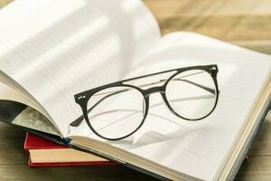 lunettes de lecture posées sur un livre ouvert photo