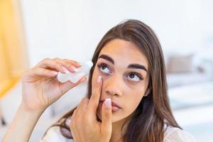 femme en utilisant œil goutte. femelle goutte œil lubrifiant à traiter sec œil ou allergie. malade fille traiter globe oculaire irritation ou inflammation malade femme Souffrance de irrité œil, optique symptômes. photo