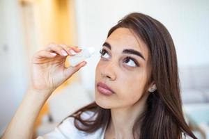 femme en utilisant œil goutte, femme goutte œil lubrifiant à traiter sec œil ou allergie, malade fille traiter globe oculaire irritation ou inflammation malade femme Souffrance de irrité œil, optique symptômes photo