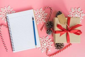 Haut vue marron cadeau boîte, carnet et Noël décoration pour Nouveau année sur rose pastel couleur. photo