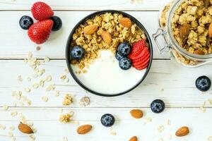 bol de granola avec yaourt, Frais baies, fraise sur bois tableau. photo