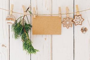 proche en haut de Noël décoration et Vide papier carte pendaison sur bois Contexte. photo