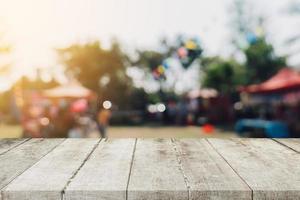 vide bois table et défocalisé bokeh et brouiller Contexte de jardin des arbres dans lumière du soleil, afficher montage pour produit. photo