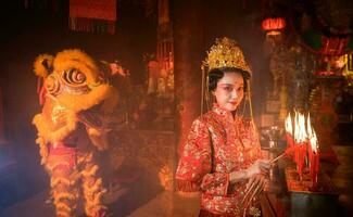 chinois femme faire vœux, prier, et lumière bougies. sur le occasion de le annuel chinois Nouveau année festival, dans une vénéré tombeau ou temple photo