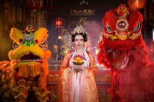 chinois femme avec Jaune et rouge les Lions il est pris en considération à améliorer le la prospérité pour soi-même sur le occasion de le chinois Nouveau année Festival chaque année photo