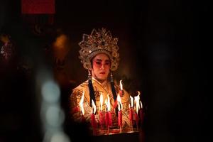 Masculin chinois opéra acteurs lumière une bougie à prier hommage à le dieux à améliorer le la prospérité pour toi même sur le occasion photo