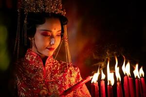 chinois femme faire vœux, prier, et lumière bougies. sur le occasion de le annuel chinois Nouveau année festival, dans une vénéré tombeau ou temple photo