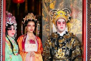 portrait de Masculin et femelle opéra interprètes à le entrée à une sacré tombeau ou temple, prier pour bénédictions sur le occasion de le annuel chinois Nouveau an. photo