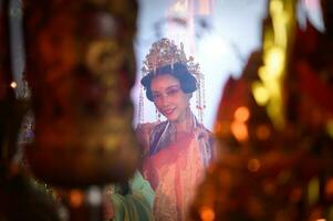 chinois femme faire vœux, prier, et lumière bougies. sur le occasion de le annuel chinois Nouveau année festival, dans une vénéré tombeau ou temple photo