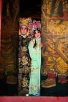 portrait de Masculin et femelle opéra interprètes à le entrée à une sacré tombeau ou temple, prier pour bénédictions sur le occasion de le annuel chinois Nouveau an. photo