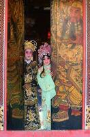 portrait de Masculin et femelle opéra interprètes à le entrée à une sacré tombeau ou temple, prier pour bénédictions sur le occasion de le annuel chinois Nouveau an. photo