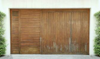 grand en bois porte sur ciment mur décoré avec vert arbre. photo