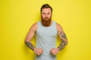 homme avec barbe et tatouages spectacles avec fierté le sien muscle photo