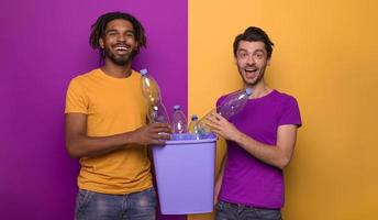 copains tenir une Plastique récipient avec bouteilles plus de Jaune et violet couleur. concept de écologie, conservation, recyclage et durabilité
