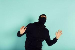 voleur avec cagoule a été Pointé en essayant à voler dans une appartement. effrayé expression photo