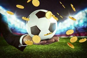 sport paris. pluie de argent sur une football Balle tenue par le main de une homme d'affaire dans une Football stade photo