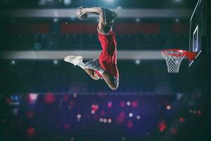 basketball Jeu avec une haute sauter joueur à faire une claquer tremper à le panier photo