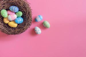 coloré Pâques des œufs dans nid sur rose pastel Couleur Contexte avec espace. photo