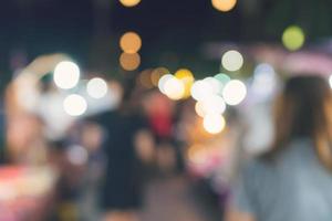 gens en marchant à Festival un événement fête nuit et bokeh flou Contexte. photo