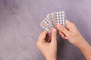 main de femme tenant des pilules contraceptives photo