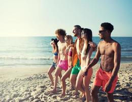 groupe de content copains ayant amusement à océan plage photo