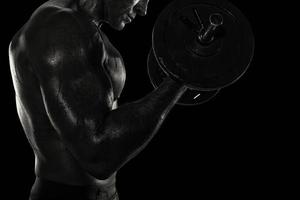 athlétique homme formation biceps à le salle de sport. noir et blanc effet photo