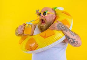 graisse faim homme avec perruque dans tête est prêt à nager avec une Donut bouée de sauvetage photo