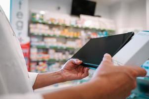 femme pharmacien chèques information sur médicaments sur le tablette photo