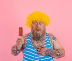 graisse étonné homme avec barbe et perruque mange une popsicle photo