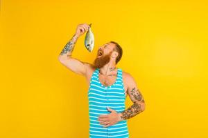 homme avec barbe et maillot de bain pris une poisson photo