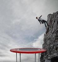 homme d'affaire sauter sur une trampoline à atteindre le drapeau. réussite affaires objectif et difficile carrière concept photo