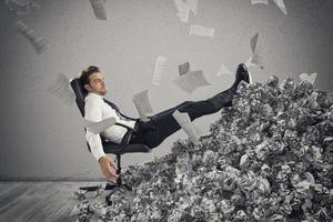 homme d'affaire avec papier feuille partout. enterré par bureaucratie. concept de surmenage photo