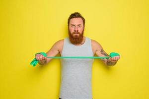 homme avec barbe et tatouages les trains avec une caoutchouc bande photo