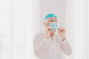 médecin avec masque et visage protecteur est prêt à travail dans hôpital photo