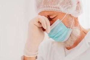 médecin avec visage masque et visage protecteur est fatigué à propos le covid-19 virus pandémie photo