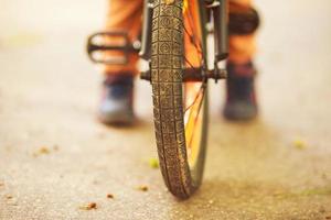 garçon avec une vélo sur le rue. roue de une enfants vélo photo