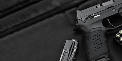 automatique noir 9 mm pistolet et balles sur noir cuir arrière-plan, sélectif et doux se concentrer, copie espace. photo