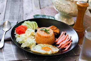 frit riz, frit œuf, concombre, tranché tomate, vert salade et frit poulet mis sur une noir assiette comme une garnir. photo