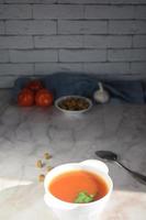 verticale encore la vie de une assiette avec tomate soupe, tomates, Ail et chapelure photo