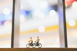voyageurs miniatures avec des vélos sur un pont de bois