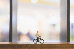 voyageur miniature avec un vélo sur un pont en bois