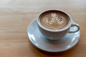 Tasse à café latte art sur table en bois photo