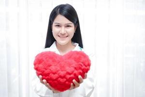 une belle femme médecin asiatique tenant un grand coeur rouge. dans la salle de soins. concepts de soins aux patients hospitalisés photo
