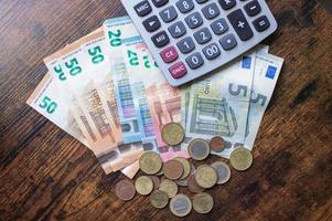 euro billets de banque et pièces de monnaie sont sur le table avec une calculatrice photo