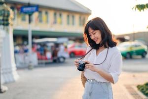 portrait de asiatique femme voyageur en utilisant caméra à rue de Bangkok, Thaïlande. Asie été tourisme vacances concept photo