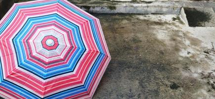 coloré à motifs parapluies dans le Cour après pluie. arc en ciel parapluie. Naturel Contexte. coloré parapluie, symbole de pluvieux temps saison. copie espace. bannière photo