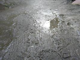 le état de le route où là sont boueux flaques d'eau cette sont humide et noir photo