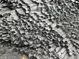 étonnantes structures rocheuses de basalte sur une plage noire sans fin d'islande. photo