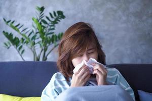 asiatique femmes sont mauvais avec fièvre et qui coule nez. photo