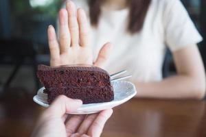 les femmes avaient l'habitude de pousser l'assiette à gâteau avec les gens. ne mangez pas de desserts pour perdre du poids. photo